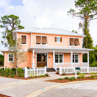 ジャクソンビルのビーチスタイルのおしゃれな家の外観 (ビニールサイディング、半切妻屋根、戸建、金属屋根、オレンジの外壁) の写真