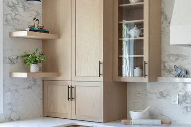 Inspiration for a large contemporary l-shaped light wood floor and brown floor kitchen pantry remodel in Philadelphia with a farmhouse sink, shaker cabinets, light wood cabinets, quartz countertops, white backsplash, quartz backsplash, stainless steel appliances, an island and white countertops