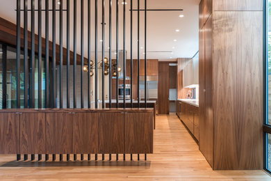 Eat-in kitchen - mid-sized modern l-shaped light wood floor and brown floor eat-in kitchen idea in Houston with an undermount sink, flat-panel cabinets, dark wood cabinets, quartz countertops, gray backsplash, porcelain backsplash and an island