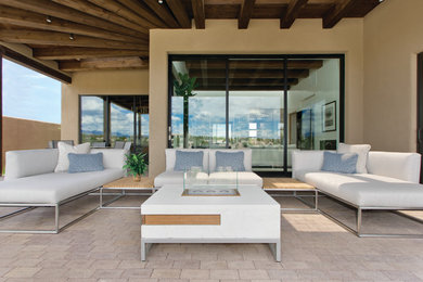 Example of a mid-sized trendy brick patio design in Albuquerque with a roof extension