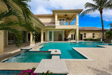 Large island style backyard custom-shaped hot tub photo in Miami
