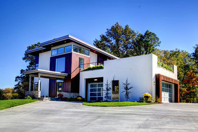 Photo of a large contemporary two-storey white exterior in Grand Rapids with mixed siding and a flat roof.