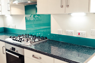 Inspiration for a modern kitchen in London with glass sheet splashback.