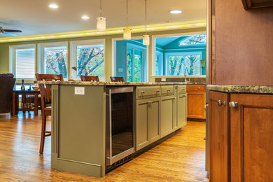 Example of a mid-sized trendy l-shaped medium tone wood floor and brown floor open concept kitchen design in Other with an undermount sink, shaker cabinets, medium tone wood cabinets, granite countertops, brown backsplash, matchstick tile backsplash, stainless steel appliances, an island and brown countertops