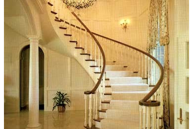 Foto de escalera curva clásica grande con escalones de madera y contrahuellas de madera pintada