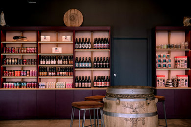 Idée de décoration pour un très grand bar de salon linéaire bohème avec des tabourets, un évier encastré, un plan de travail en stratifié et sol en béton ciré.