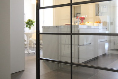 Esempio di un ampio cucina con isola centrale moderno chiuso con lavello sottopiano, ante lisce, ante bianche, top in marmo, paraspruzzi bianco, paraspruzzi in marmo, elettrodomestici in acciaio inossidabile, pavimento con piastrelle in ceramica, pavimento grigio e top bianco