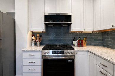 Transitional l-shaped vinyl floor and brown floor kitchen photo in DC Metro with shaker cabinets, white cabinets, quartz countertops, black backsplash, subway tile backsplash, stainless steel appliances, no island, multicolored countertops and a drop-in sink