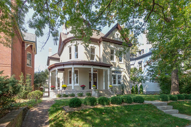 Mid-sized elegant beige two-story stucco exterior home photo with a hip roof