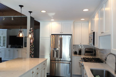 Open concept kitchen - mid-sized traditional l-shaped open concept kitchen idea in Chicago with an undermount sink, flat-panel cabinets, white cabinets, quartz countertops, white backsplash, subway tile backsplash and stainless steel appliances