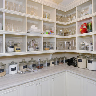 Inspiration for a mid-sized traditional l-shaped kitchen pantry in Toronto with recessed-panel cabinets, white cabinets, laminate benchtops and porcelain floors.