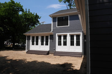 Ejemplo de fachada de casa azul tradicional renovada de tamaño medio de dos plantas con revestimiento de aglomerado de cemento, tejado a dos aguas y tejado de teja de madera