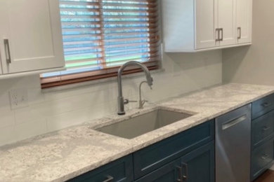 Transitional vinyl floor and brown floor kitchen photo in Other with an undermount sink, recessed-panel cabinets, blue cabinets, quartz countertops, white backsplash, ceramic backsplash, stainless steel appliances and multicolored countertops