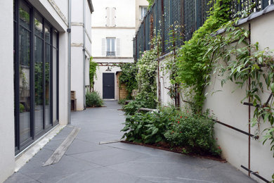 Aménagement d'un jardin sur cour contemporain avec des solutions pour vis-à-vis, une exposition partiellement ombragée, un paillis et une clôture en métal.