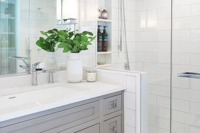 Design ideas for a mid-sized transitional master bathroom in Toronto with shaker cabinets, grey cabinets, an alcove shower, a one-piece toilet, white tile, ceramic tile, white walls, porcelain floors, an undermount sink, engineered quartz benchtops, white floor and a hinged shower door.