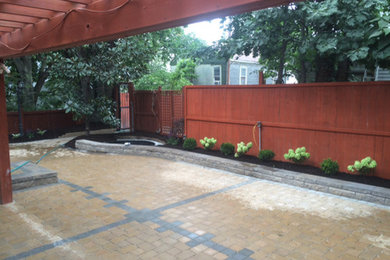 Imagen de patio contemporáneo de tamaño medio en patio trasero con adoquines de hormigón y pérgola