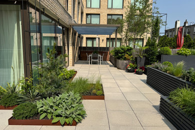 Photo of a large modern drought-tolerant and partial sun rooftop landscaping in New York for summer.