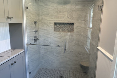 Alcove shower - mid-sized modern master gray tile and ceramic tile ceramic tile, gray floor, single-sink and wainscoting alcove shower idea in Boston with flat-panel cabinets, gray cabinets, a one-piece toilet, gray walls, a drop-in sink, quartz countertops, a hinged shower door, gray countertops, a niche and a freestanding vanity