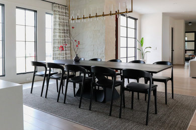 Idée de décoration pour une grande salle à manger ouverte sur la cuisine minimaliste avec un mur blanc et parquet clair.