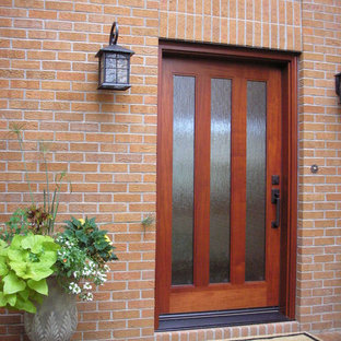 Immagine di una porta d'ingresso minimalista di medie dimensioni con pareti rosse, una porta singola e una porta in legno bruno