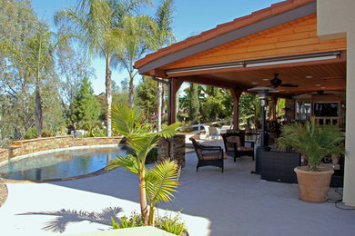 Inspiration for a large traditional backyard custom-shaped pool in San Diego with a hot tub and concrete slab.