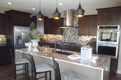 Eat-in kitchen - mid-sized traditional l-shaped dark wood floor eat-in kitchen idea in Orange County with an undermount sink, shaker cabinets, dark wood cabinets, granite countertops, gray backsplash, matchstick tile backsplash, stainless steel appliances and an island