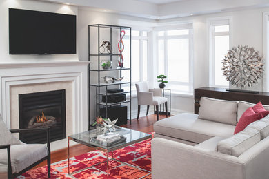 Family room - mid-sized contemporary medium tone wood floor and brown floor family room idea in Toronto with gray walls, a standard fireplace, a wall-mounted tv and a stone fireplace