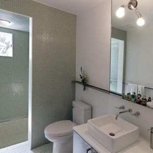 Idées déco pour une petite douche en alcôve principale moderne avec une vasque, un placard à porte plane, un plan de toilette en surface solide, un WC à poser, un carrelage en pâte de verre, un mur blanc, des portes de placard grises, un carrelage vert, sol en terrazzo, un sol gris et aucune cabine.