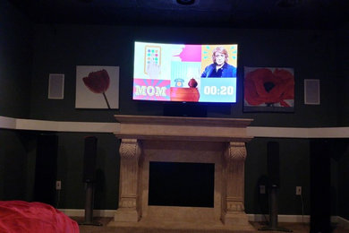 Mid-sized elegant open concept carpeted living room photo in Little Rock with black walls, a standard fireplace, a plaster fireplace and a wall-mounted tv