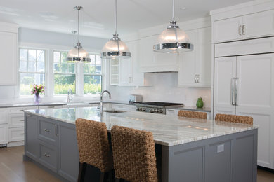 Large transitional l-shaped medium tone wood floor and brown floor open concept kitchen photo in Boston with a farmhouse sink, shaker cabinets, white cabinets, granite countertops, white backsplash, stainless steel appliances and an island