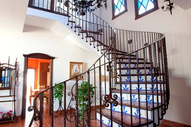Ejemplo de escalera curva rural de tamaño medio con escalones con baldosas y contrahuellas con baldosas y/o azulejos