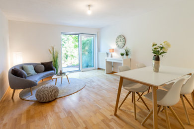 Mittelgroßes Wohnzimmer mit braunem Holzboden in München