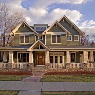 Foto på ett amerikanskt grönt hus, med två våningar, sadeltak och tak i shingel