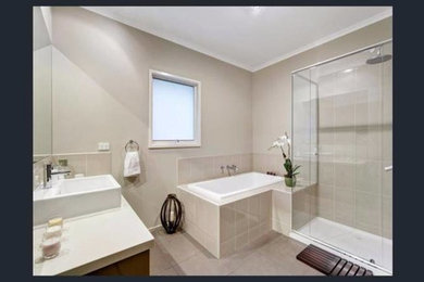 Mid-sized minimalist master ceramic tile ceramic tile bathroom photo in Melbourne with glass-front cabinets, white cabinets, a one-piece toilet, a pedestal sink, marble countertops, a hinged shower door and white countertops