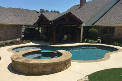 Mid-sized backyard custom-shaped natural pool in Dallas with a hot tub and decking.