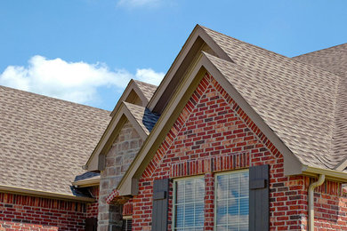 Example of a mid-sized classic red two-story brick exterior home design in Columbus with a hip roof