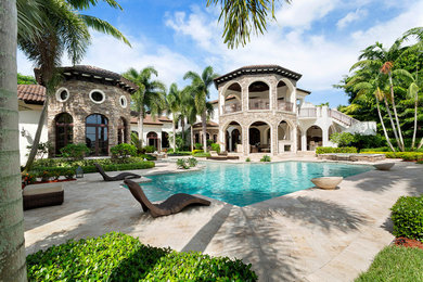 Inspiration for a mid-sized contemporary backyard custom-shaped natural pool in Miami with a hot tub and brick pavers.