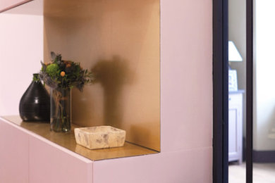 Inspiration pour un hall d'entrée minimaliste de taille moyenne avec un mur rose, un sol en bois brun, une porte simple, une porte métallisée et un sol beige.