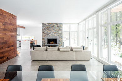 Mid-sized minimalist open concept ceramic tile and beige floor living room photo in Burlington with white walls, a wood stove, a stone fireplace and no tv