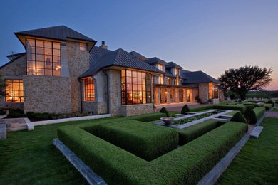 This is an example of an expansive country two-storey exterior in Austin with stone veneer.