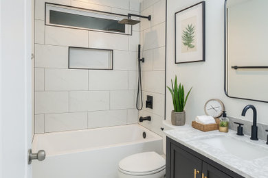 Bathroom - small kids' white tile and porcelain tile single-sink bathroom idea in Charleston with raised-panel cabinets, black cabinets, a two-piece toilet, white walls, an undermount sink, marble countertops, white countertops, a niche and a freestanding vanity