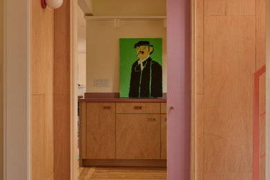Mid-sized 1960s u-shaped medium tone wood floor eat-in kitchen photo in Providence with an undermount sink, flat-panel cabinets, concrete countertops, pink backsplash, cement tile backsplash, paneled appliances, no island and pink countertops