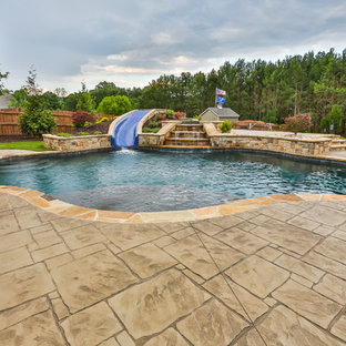 Mittelgroßer Klassischer Schwimmteich hinter dem Haus in individueller Form mit Wasserrutsche und Stempelbeton in Atlanta