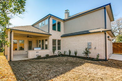 Inspiration for a mid-sized contemporary beige two-story mixed siding exterior home remodel in Dallas with a hip roof