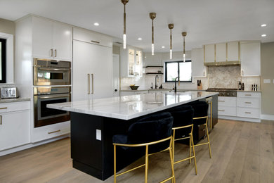 Example of a large trendy l-shaped light wood floor and multicolored floor open concept kitchen design in San Francisco with an undermount sink, flat-panel cabinets, white cabinets, quartzite countertops, white backsplash, ceramic backsplash, paneled appliances, an island and white countertops
