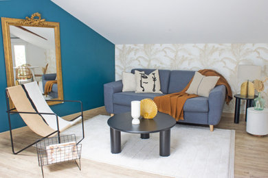 Cette image montre un salon mansardé ou avec mezzanine design de taille moyenne avec un mur bleu, parquet clair, aucun téléviseur et du papier peint.