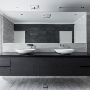 Esempio di una stanza da bagno padronale minimalista di medie dimensioni con lavabo sottopiano, ante lisce, ante in legno bruno, top in quarzo composito, vasca freestanding, doccia aperta, WC monopezzo, piastrelle nere, piastrelle in gres porcellanato, pareti bianche e pavimento in gres porcellanato