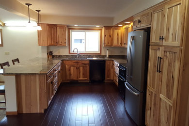 Example of an u-shaped dark wood floor eat-in kitchen design in Other with an undermount sink, stainless steel appliances and a peninsula
