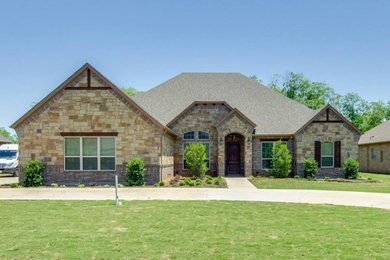 Mid-sized rustic beige one-story stone exterior home idea in Dallas with a hip roof