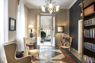 This is an example of a mid-sized traditional open concept family room in Florence with a library, beige walls, marble floors and multi-coloured floor.